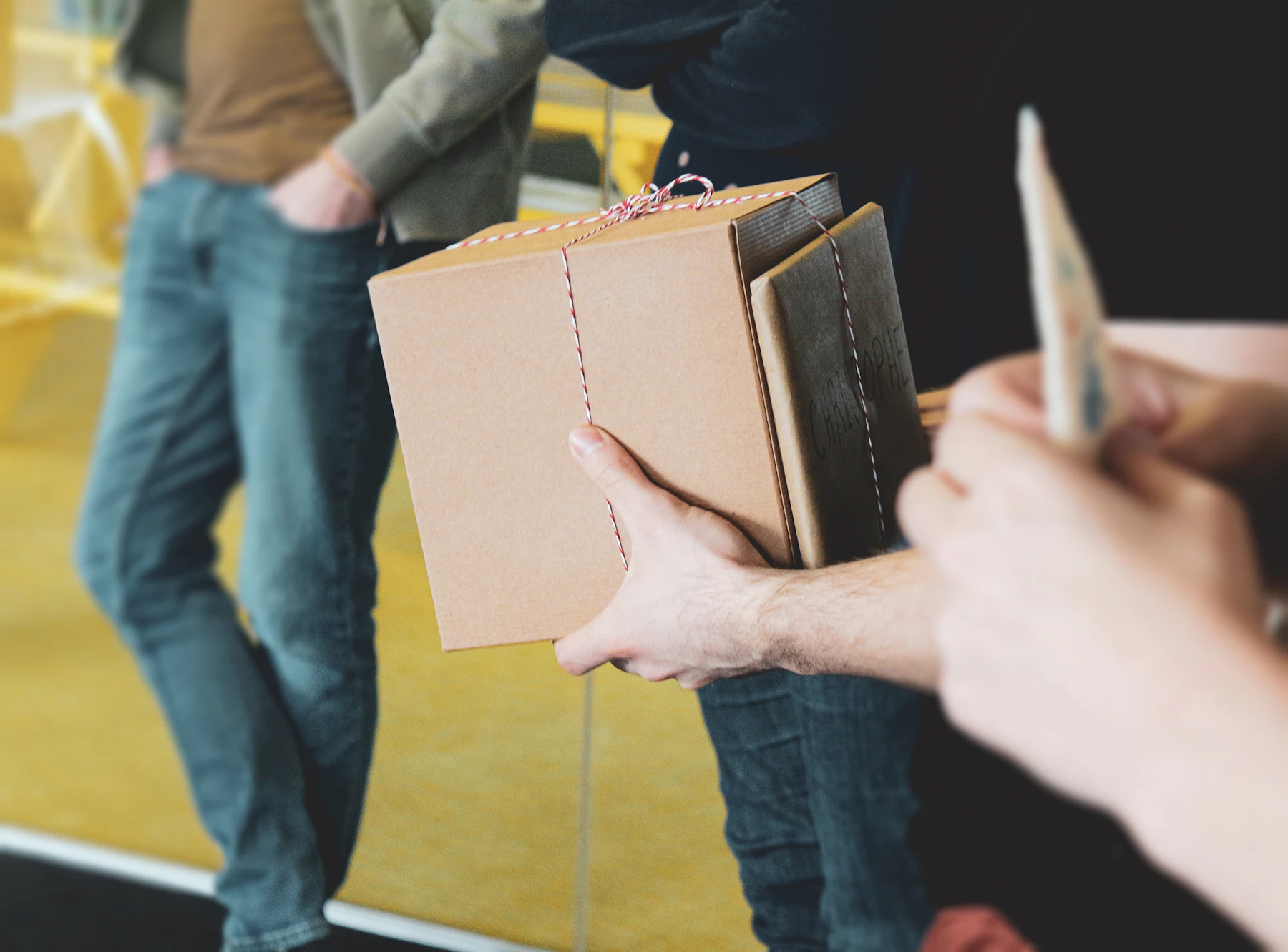 Person holding a small brown parcel tied with string