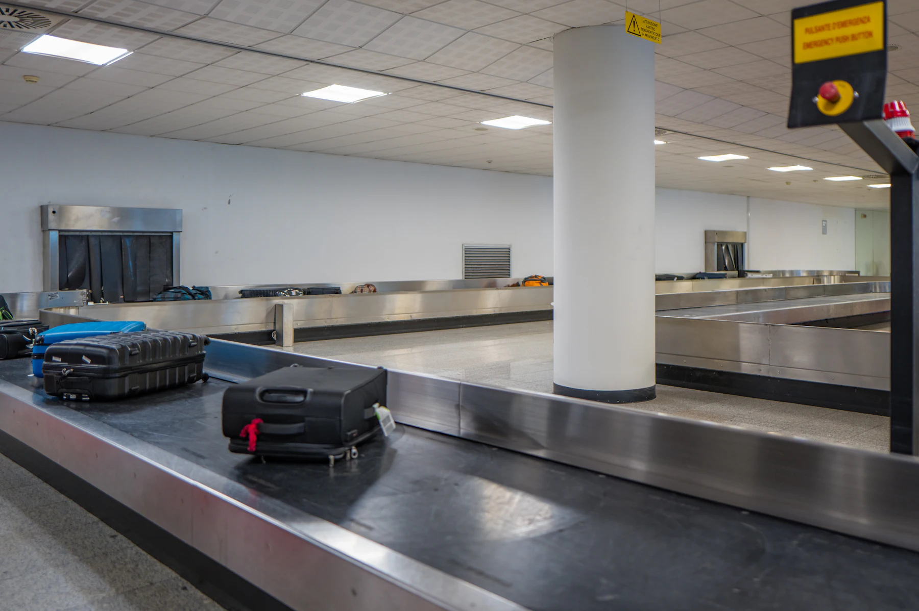 Suitcases and bags moving along an airport baggage handling conveyor belt