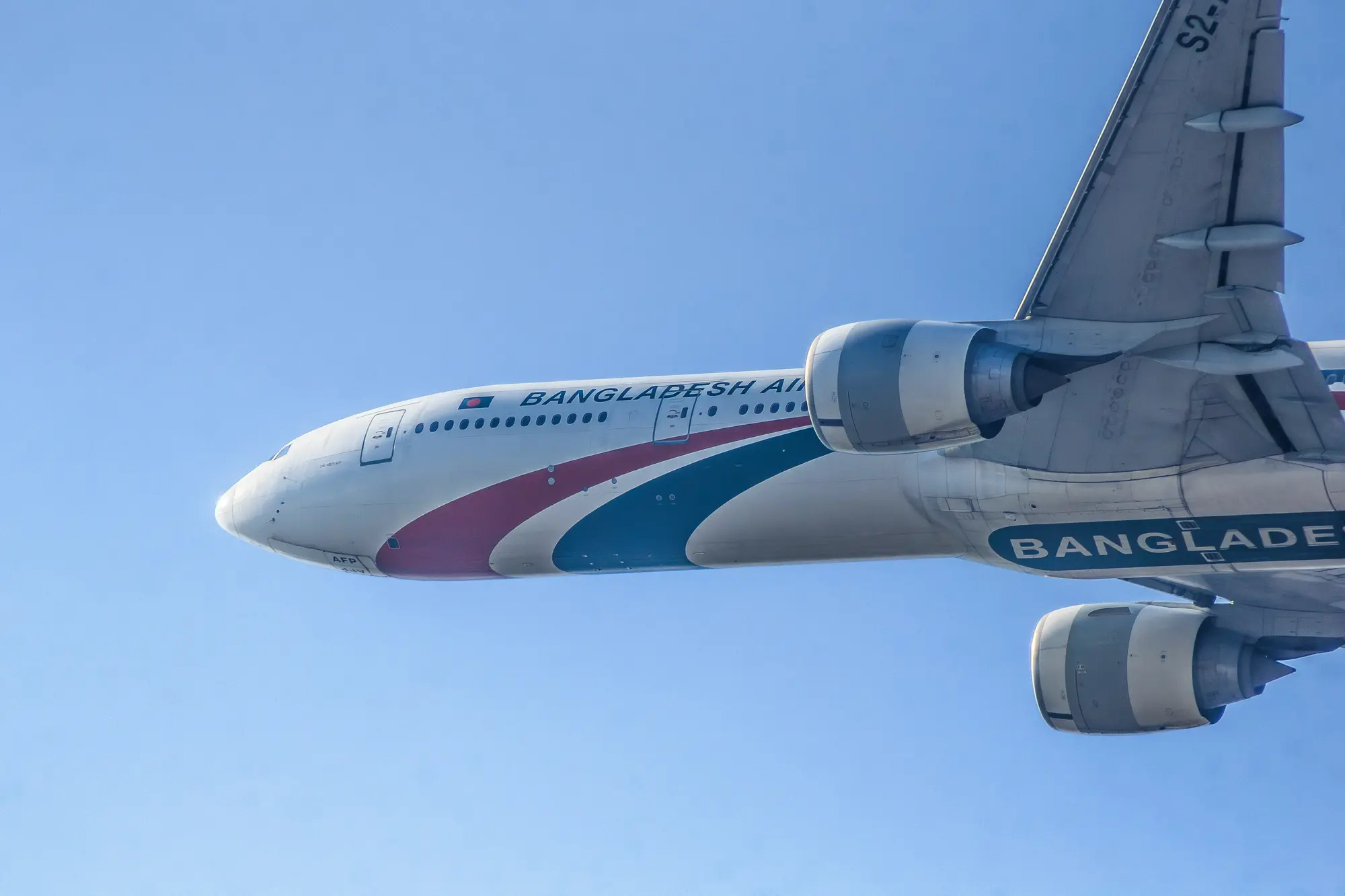 Home Biman Bangladesh Airlines aircraft flying in a clear blue sky