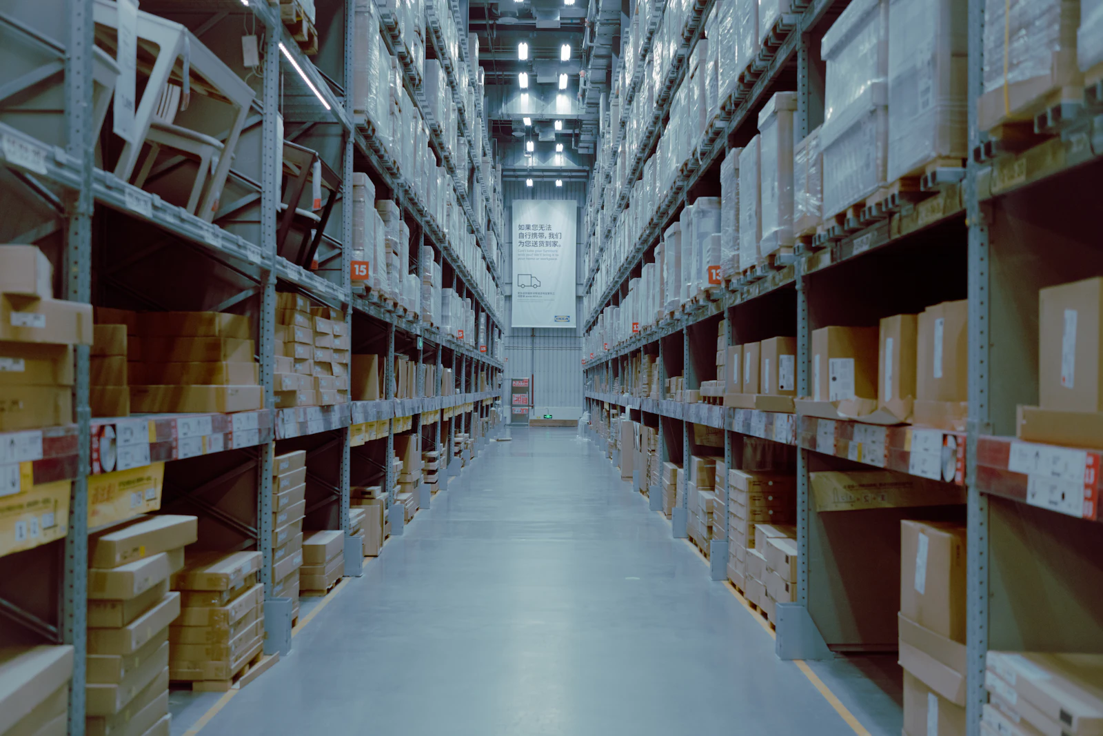 Wide warehouse interior with tall racking and palletised goods on the shelves